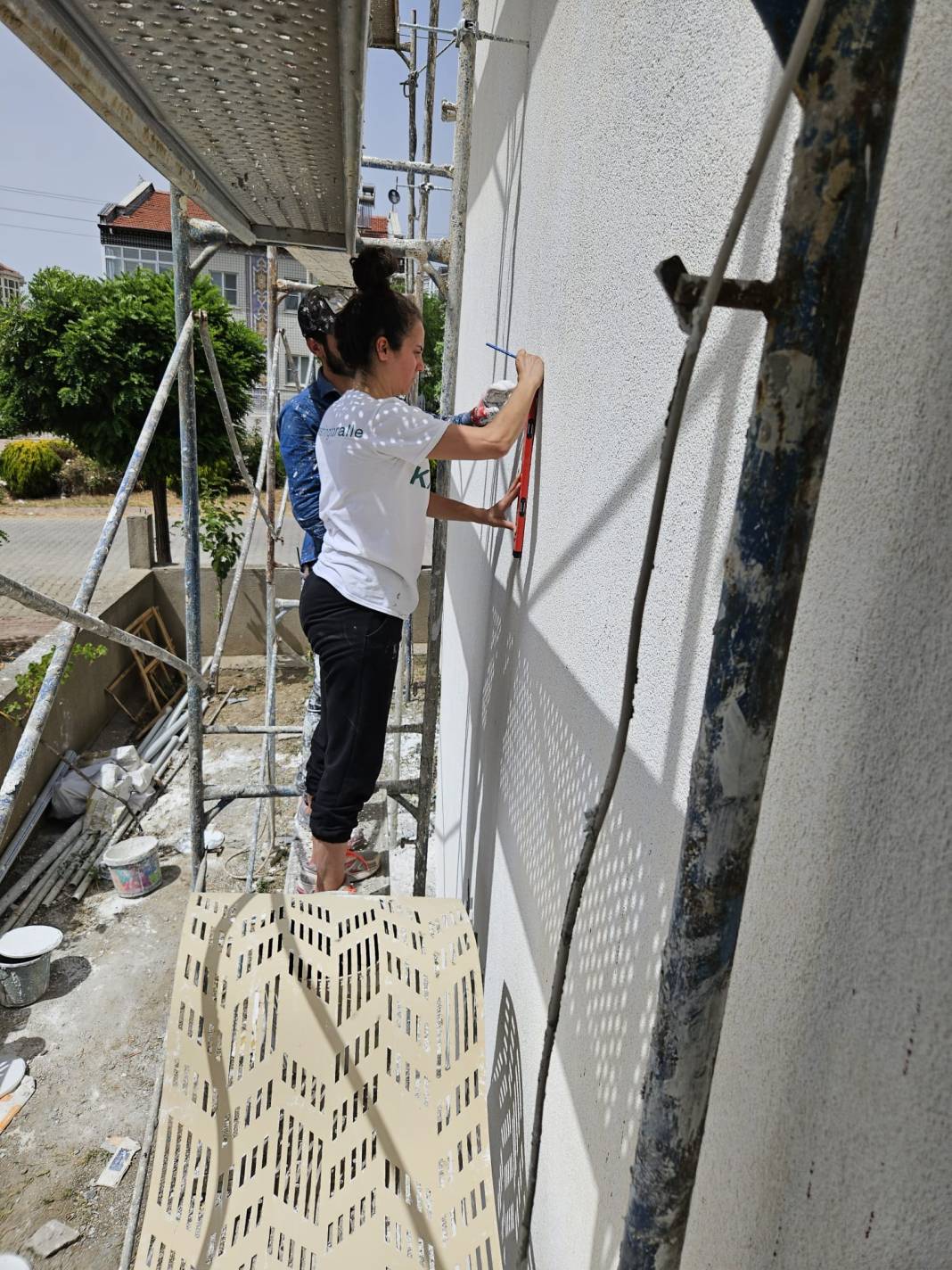 2 çocuk annesi Hilal, mala, fırça ve boya ile binalara dekoratif sıva yapıyor 5